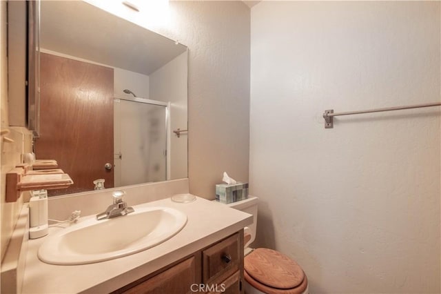 bathroom featuring walk in shower, vanity, and toilet