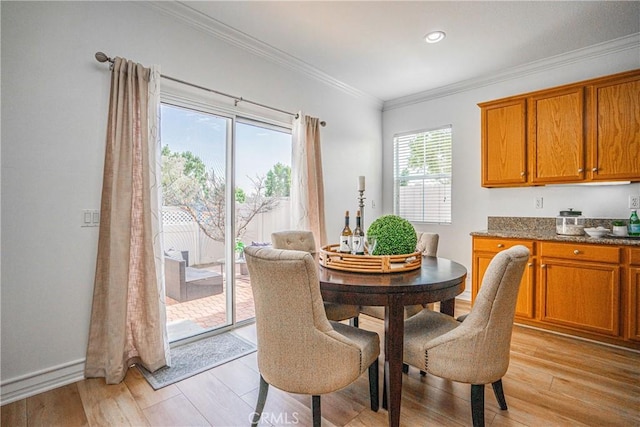 dining area featuring crown molding and light wood-type flooring