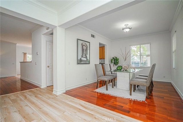 dining area with ornamental molding and light wood-type flooring