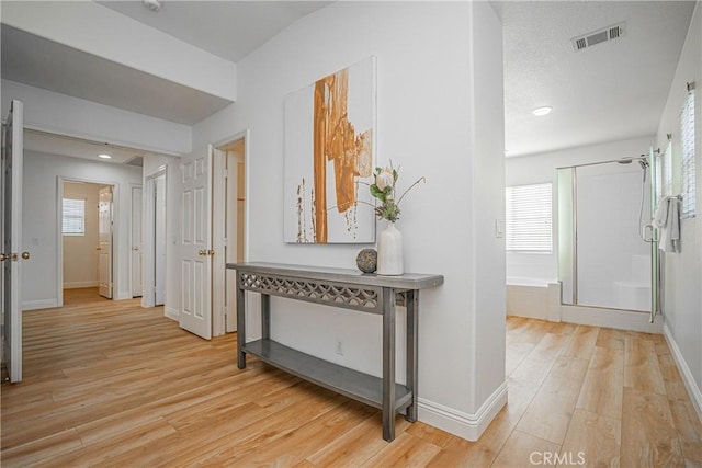 corridor with light hardwood / wood-style floors