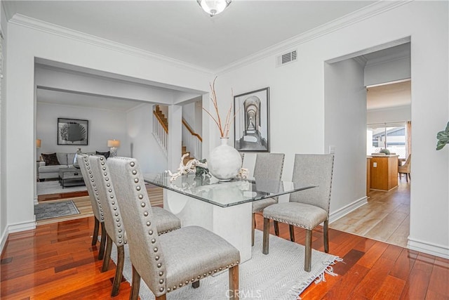 dining room featuring crown molding and wood-type flooring