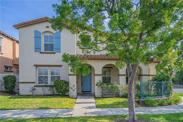 mediterranean / spanish home with a front lawn