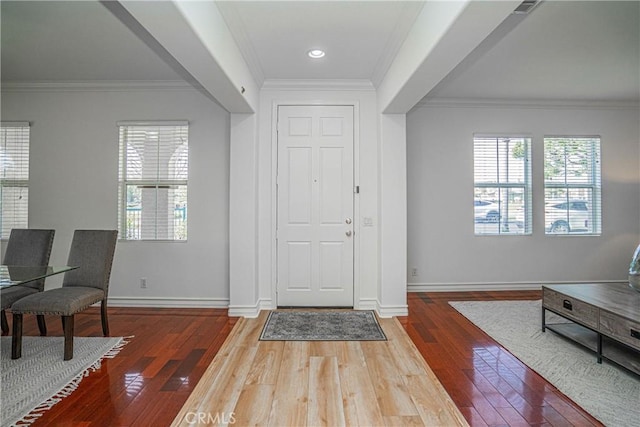 foyer entrance with wood-type flooring and ornamental molding