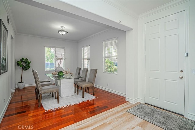 dining space with wood-type flooring and ornamental molding