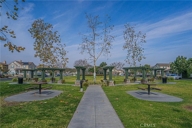 surrounding community with a yard and a pergola