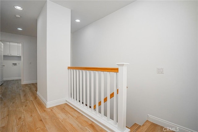 hallway with light hardwood / wood-style floors