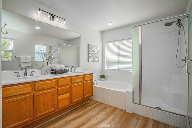 bathroom with hardwood / wood-style flooring, vanity, and separate shower and tub