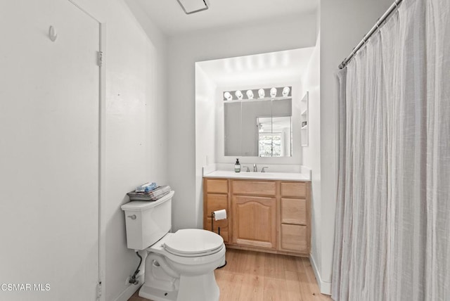 bathroom featuring wood-type flooring, toilet, and vanity