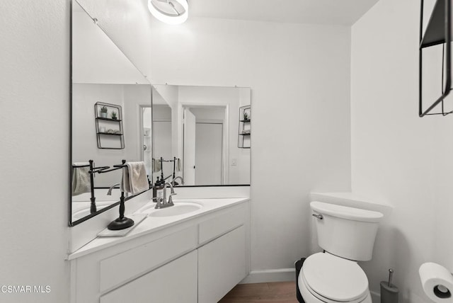 bathroom featuring vanity, wood-type flooring, and toilet