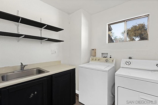 washroom with cabinets, sink, and washing machine and clothes dryer