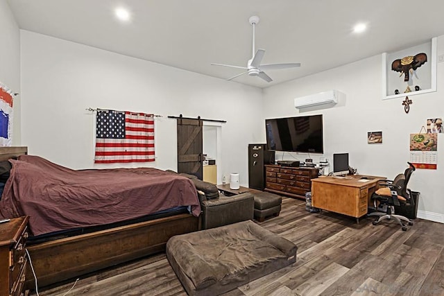 bedroom featuring wood-type flooring, a barn door, ceiling fan, and a wall unit AC