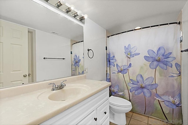 bathroom with vanity, toilet, and tile patterned flooring