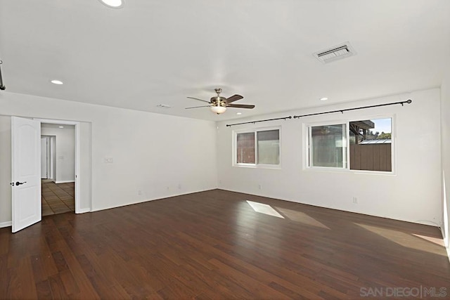 spare room with dark wood-type flooring and ceiling fan