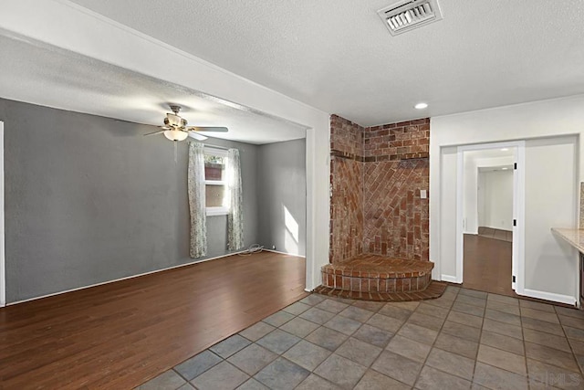 unfurnished living room featuring hardwood / wood-style floors, a textured ceiling, and ceiling fan