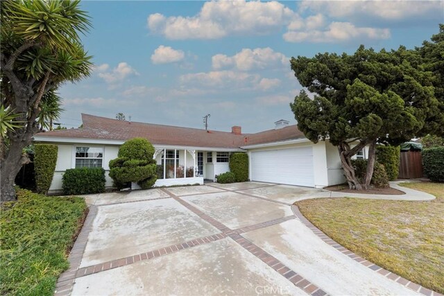 ranch-style home with a garage and a front lawn