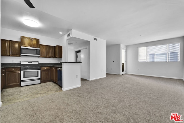 kitchen featuring appliances with stainless steel finishes, light colored carpet, and dark brown cabinetry