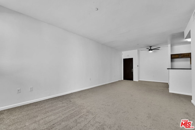 unfurnished living room featuring ceiling fan and carpet flooring