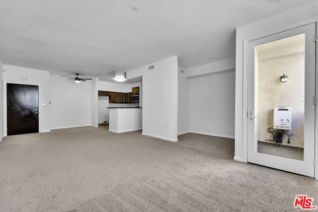 unfurnished living room with light colored carpet and ceiling fan