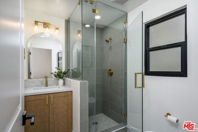 bathroom with vanity and a shower with shower door