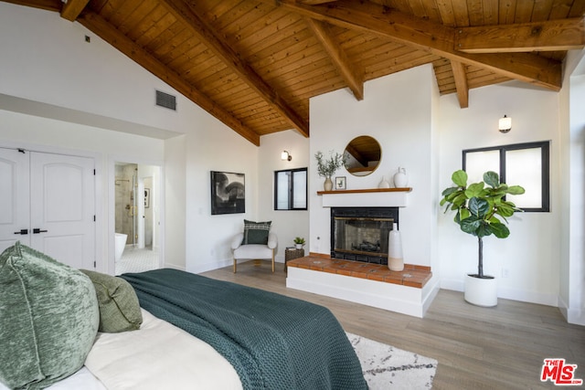 bedroom with wood ceiling, hardwood / wood-style floors, high vaulted ceiling, a fireplace, and beamed ceiling