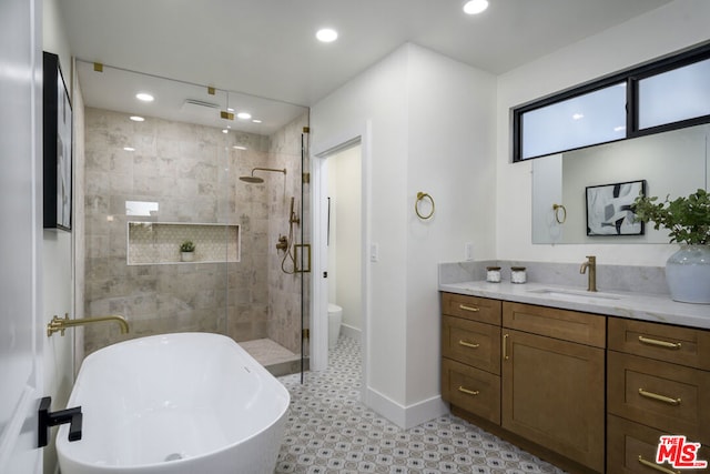 full bathroom featuring shower with separate bathtub, vanity, and toilet