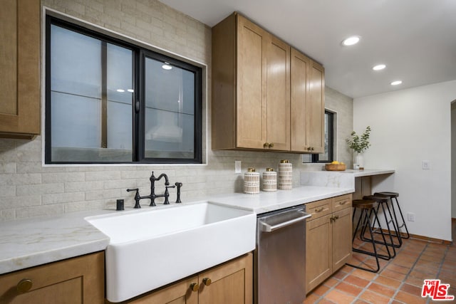 kitchen with sink, backsplash, stainless steel dishwasher, and light tile patterned floors