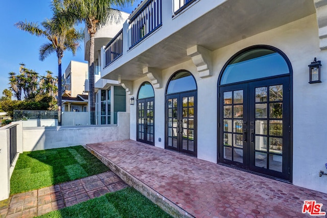 view of exterior entry featuring a patio and french doors