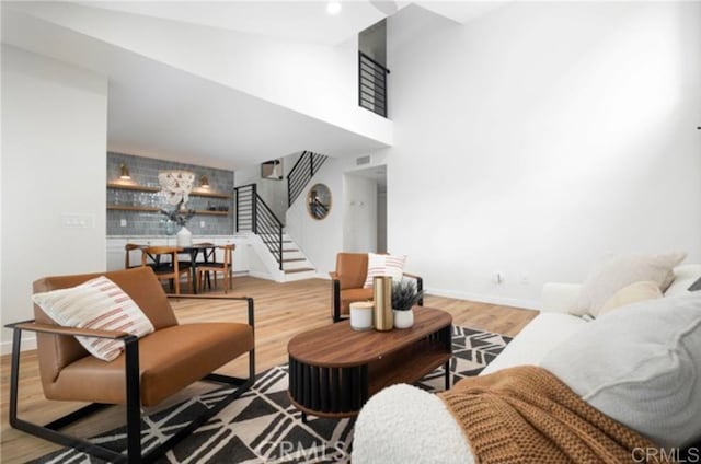 living room with a towering ceiling and light hardwood / wood-style floors