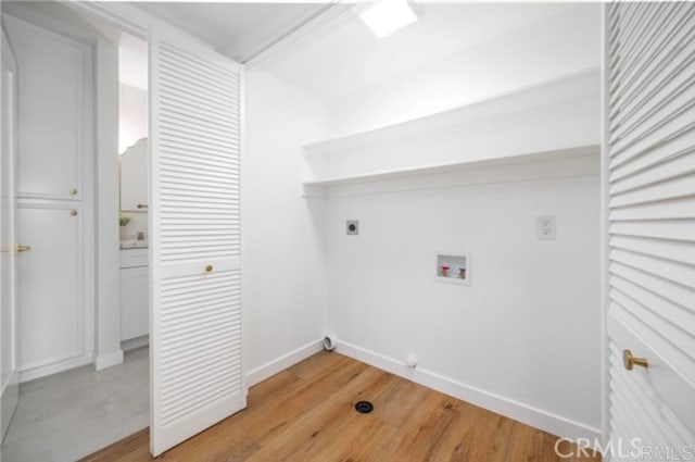 clothes washing area with light hardwood / wood-style floors, hookup for a washing machine, and electric dryer hookup