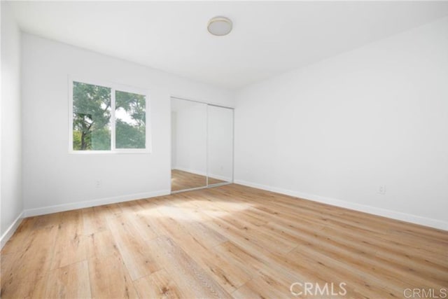 unfurnished bedroom featuring hardwood / wood-style floors and a closet