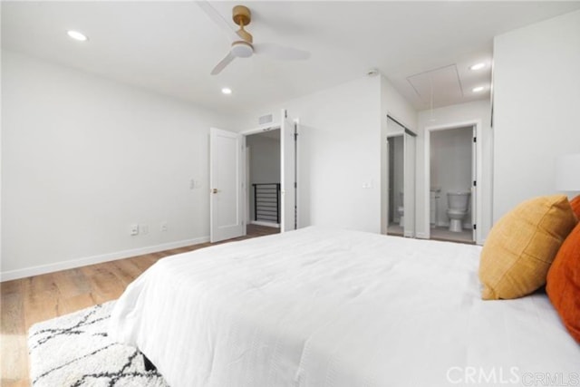 bedroom with hardwood / wood-style flooring, connected bathroom, and ceiling fan