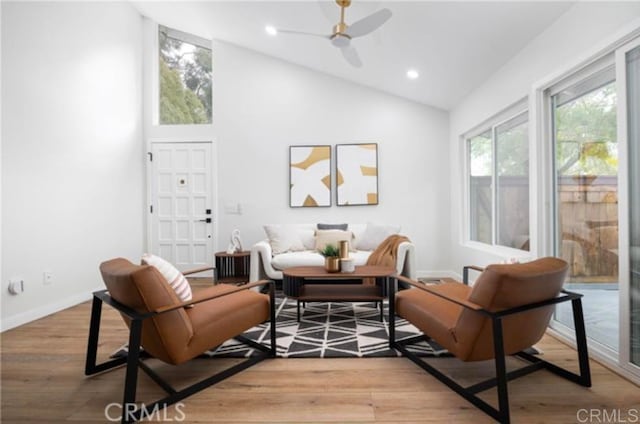 living area with ceiling fan, high vaulted ceiling, and hardwood / wood-style floors