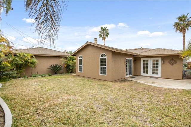 rear view of house with a yard, a patio area, and french doors