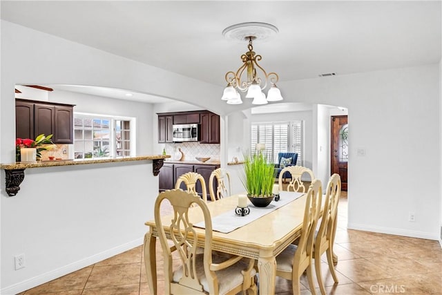 dining space featuring an inviting chandelier and light tile patterned floors