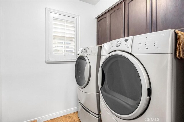 laundry room featuring cabinets, washer and dryer, and light tile patterned floors