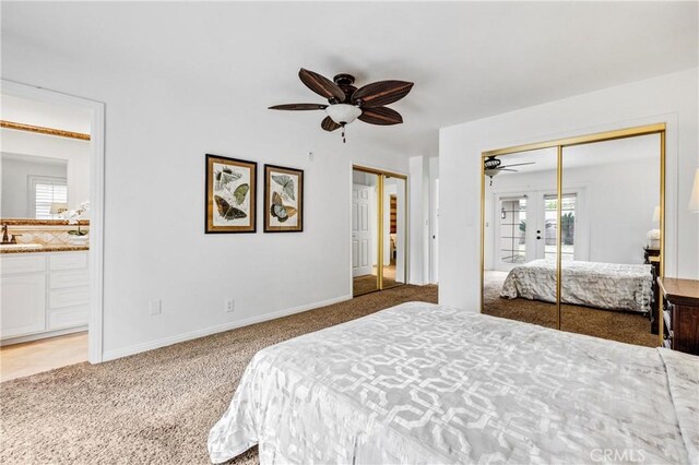 bedroom featuring ensuite bathroom, sink, carpet, multiple closets, and french doors