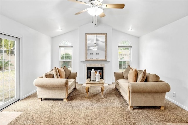 sitting room with a tile fireplace, lofted ceiling, carpet floors, and a wealth of natural light