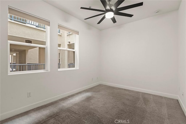 carpeted spare room featuring ceiling fan