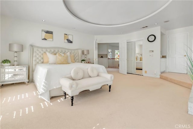 carpeted bedroom with a tray ceiling