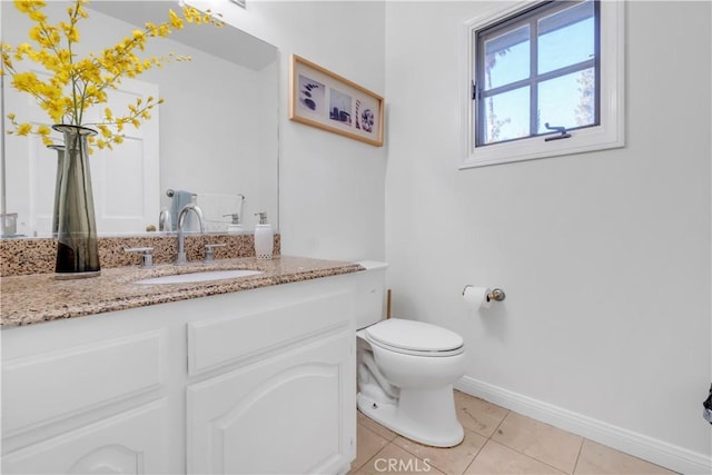 bathroom with tile patterned flooring, vanity, and toilet