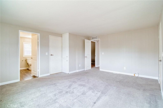 unfurnished bedroom with light carpet and ensuite bath