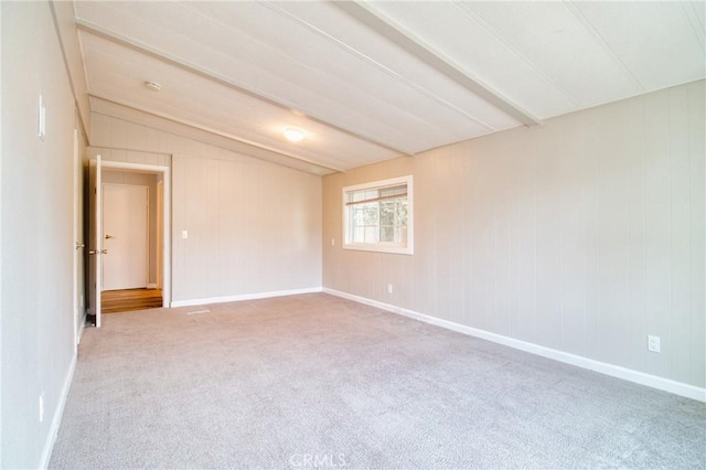 carpeted spare room with vaulted ceiling with beams