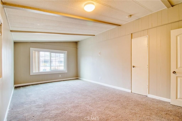 spare room with beamed ceiling and carpet