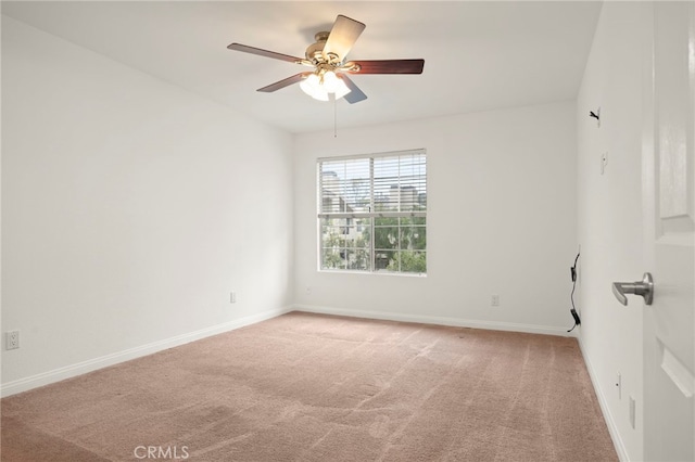 carpeted empty room featuring ceiling fan and baseboards