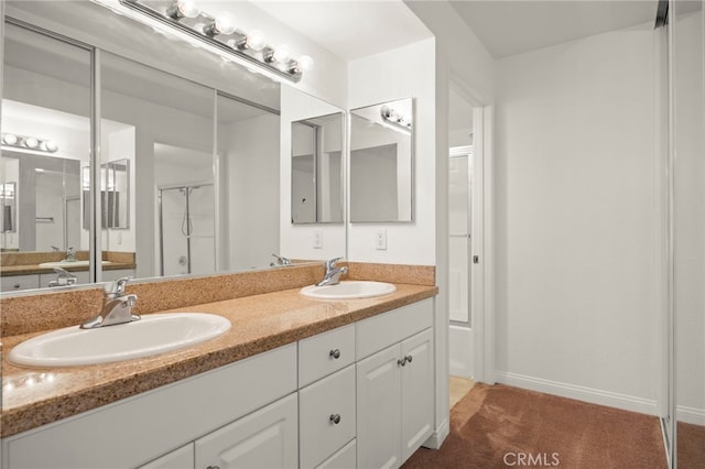 bathroom featuring double vanity, a sink, and baseboards