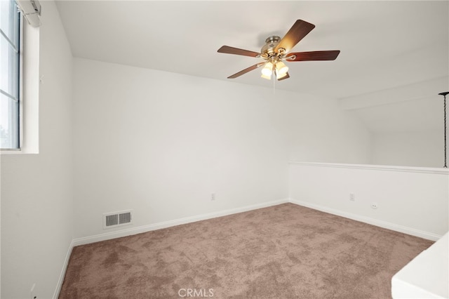 carpeted empty room featuring a ceiling fan, visible vents, and baseboards