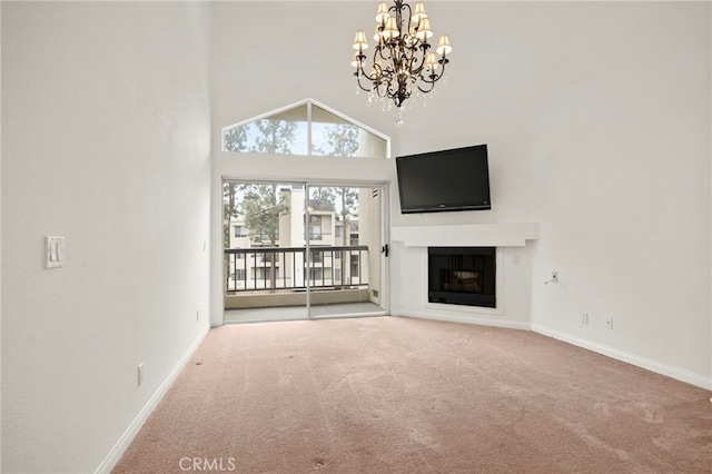 unfurnished living room featuring a high ceiling, carpet, and an inviting chandelier