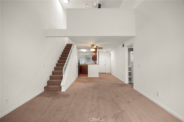 unfurnished living room with ceiling fan and light colored carpet