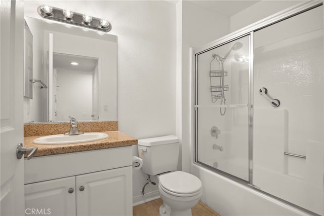 full bathroom with enclosed tub / shower combo, vanity, and toilet