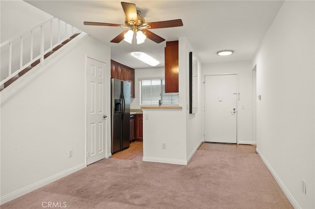 kitchen with light carpet, baseboards, light countertops, and stainless steel refrigerator with ice dispenser